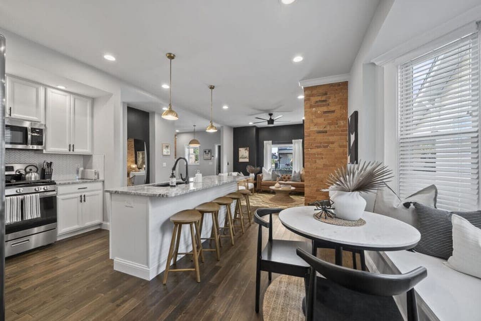 Modern kitchen with stainless steel appliances and granite countertops   - Spacious island seating ideal for meals or conversation   - Open layout connects kitchen to living and dining areas
