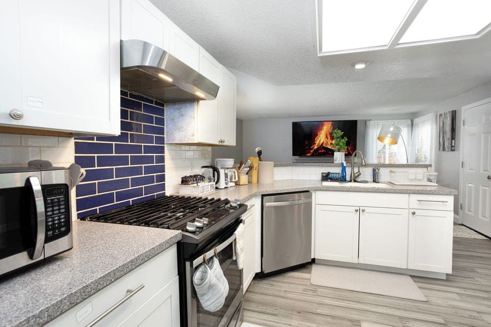 Kitchen with refrigerator, cooking stove, oven, microwave, cooking utensils