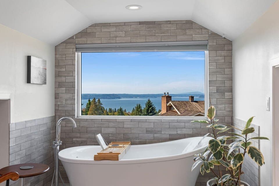 Soak in pure bliss—unwind in a luxurious tub with serene views through a picture-perfect window.