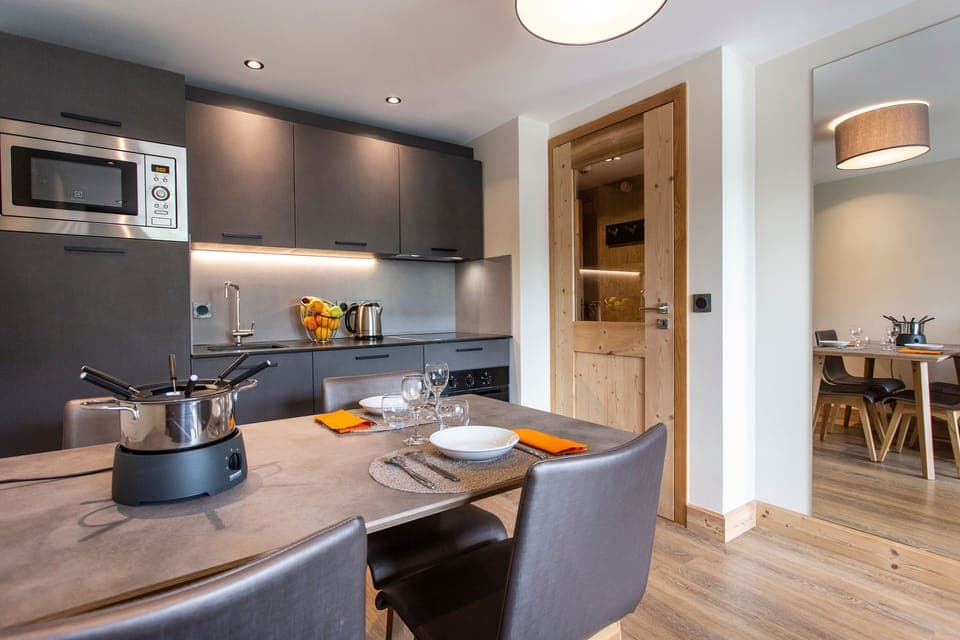 Contemporary kitchen with sleek cabinetry and wood flooring, ideal for Alpine-inspired meals.