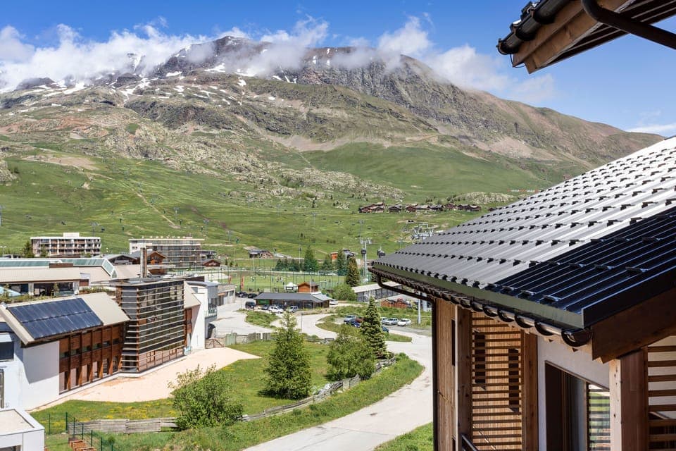 Breathtaking balcony view over the village rooftops and towering peaks beyond.