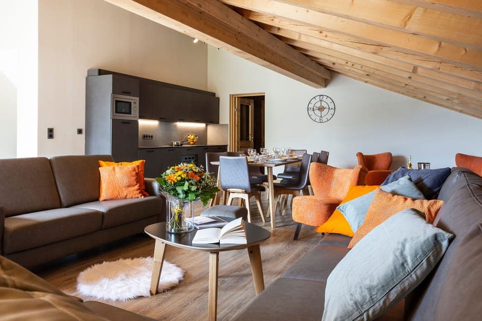 Chic and airy living space with rustic beams, pops of color, and sweeping skylights.