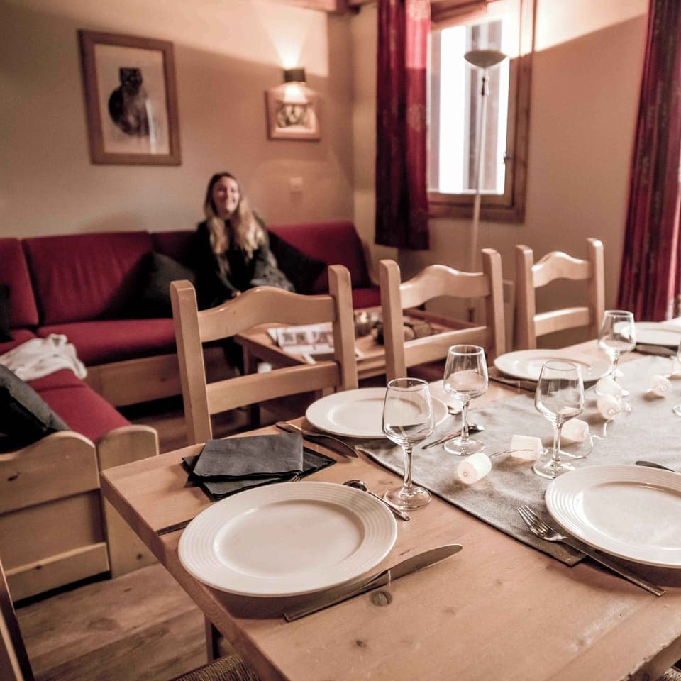Dining area set for a meal, accented by natural light and warm tones.