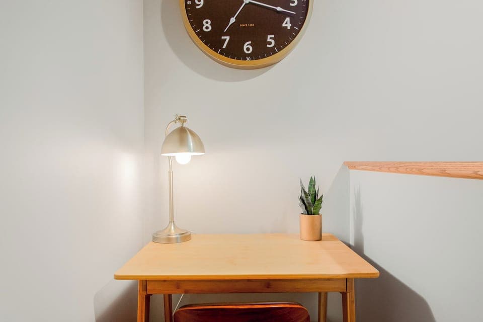 Dedicated workspace with a desk, chair, lamp, and clock