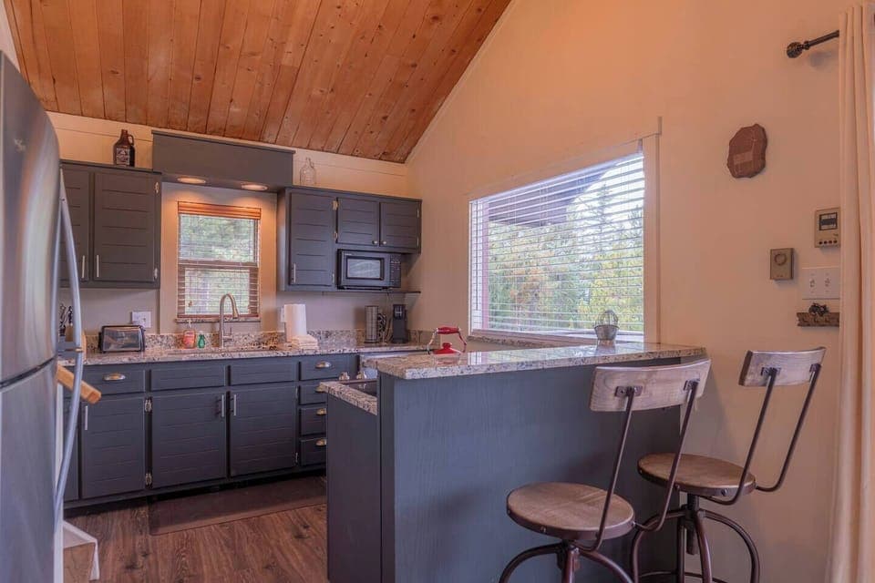 The dining table seats four, with two additional spots at the kitchen bar top.