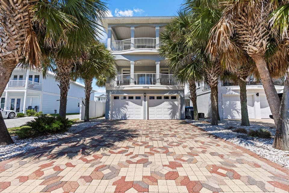 Coastal paradise awaits at this stunning beachside property, featuring elegant architecture framed by swaying palms and tropical landscaping.