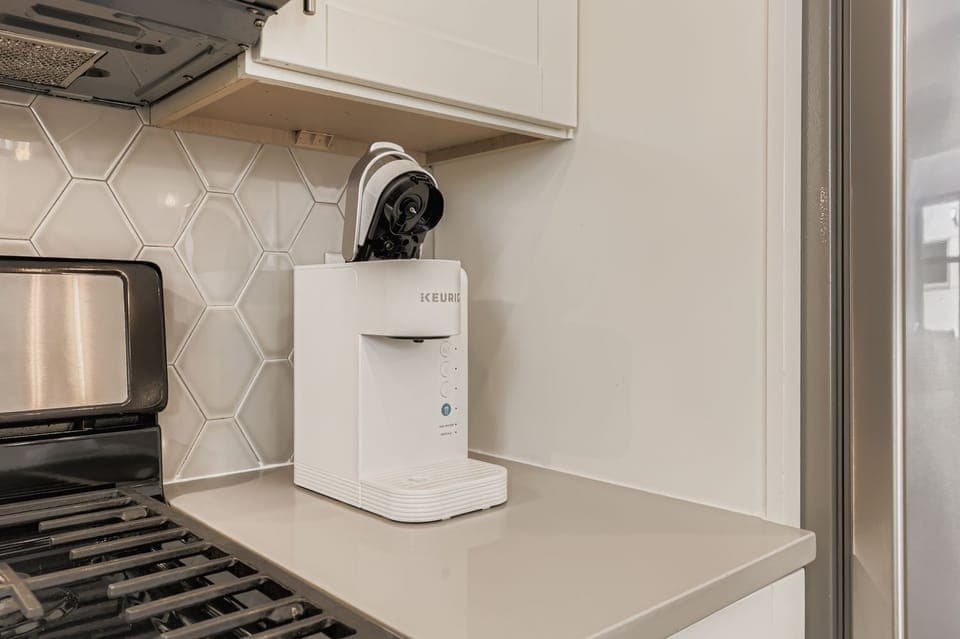 Start your mornings right with this convenient coffee station, perfectly positioned in your stylish kitchen for easy brewing.