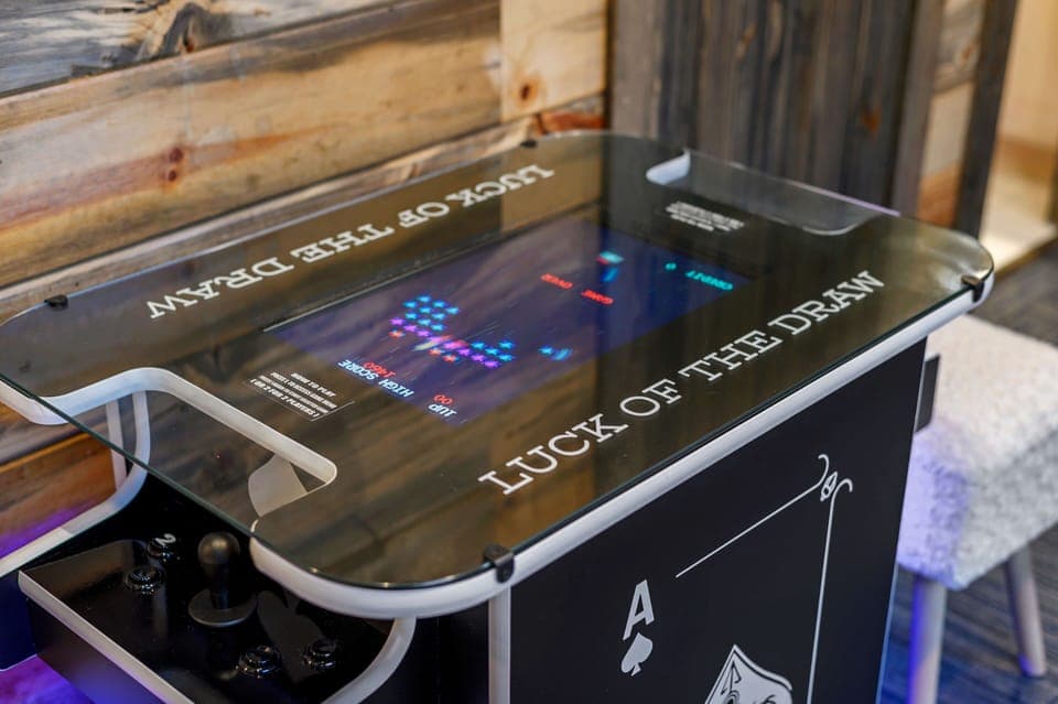 Tabletop arcade with 60 classic games and bold card-themed design in wood cabin.