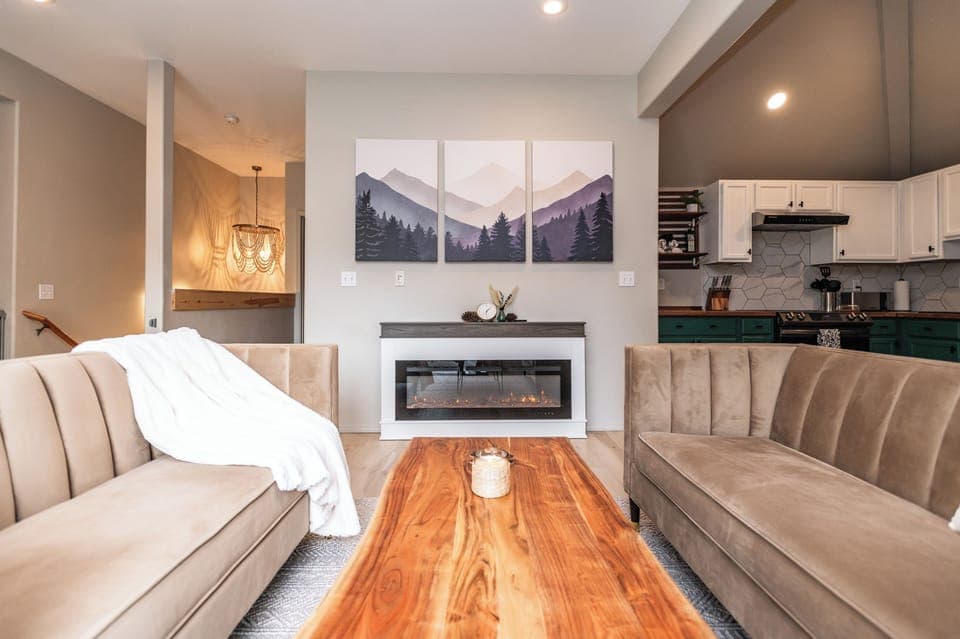 Stylish living room with fireplace and mountain art—perfect for family time.