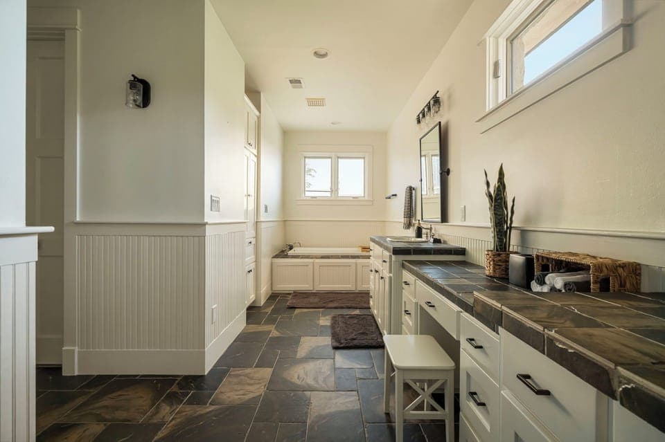 Full bathroom featuring a built-in tub under bright windows.