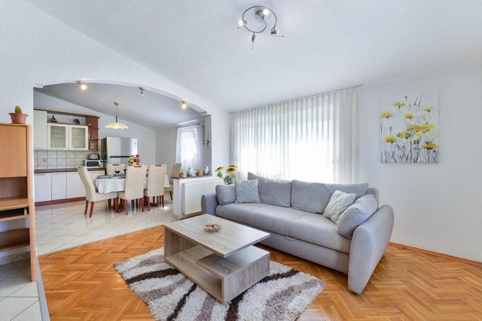 Open-plan living room with sofa, dining area, kitchen, WiFi internet, and satellite TV