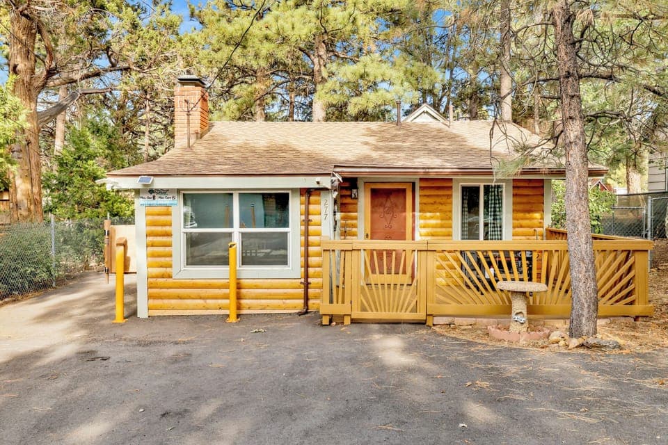 Welcoming cabin entry surrounded by towering pine trees, offering fresh mountain air and a peaceful forest setting—the perfect first impression for your Big Bear Lake getaway.