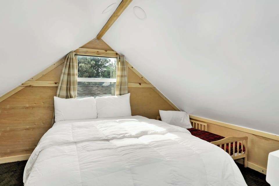 Peaceful cabin bedroom with plush bedding, and beautiful views—ideal for restful nights, cozy mornings, and a relaxing mountain escape.