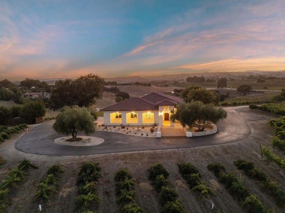 Stunning twilight exterior of the home with vineyard view.