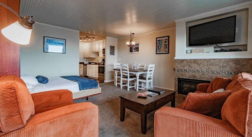 The inviting living space showcases a dining area and full kitchen, ideal for enjoying meals in the comfort of your studio.