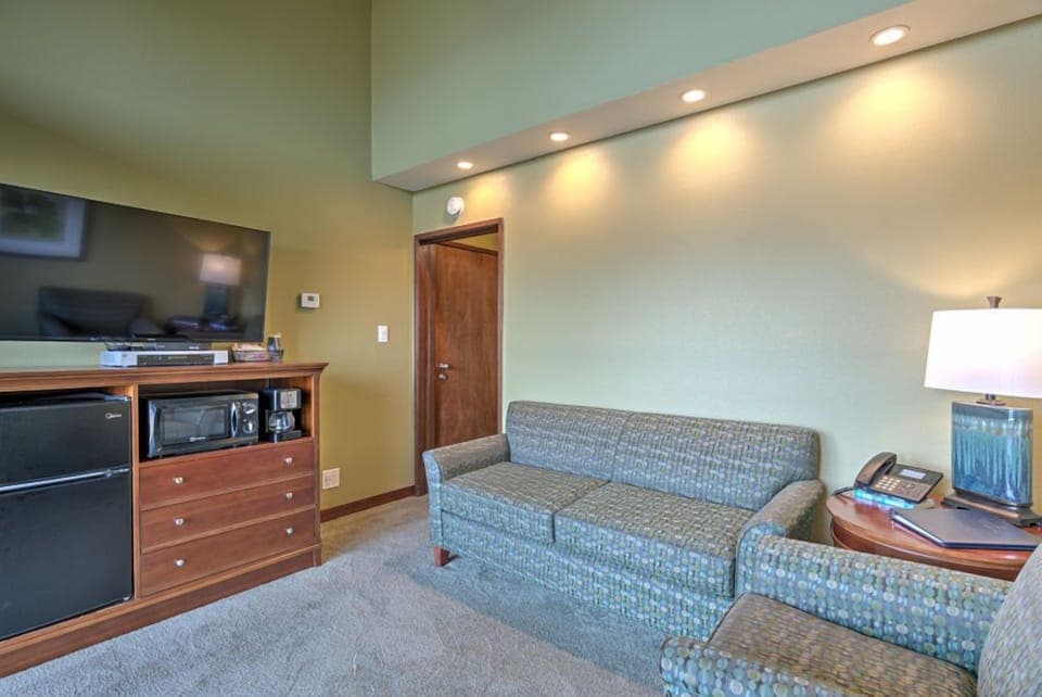 The living area also has modern appliances such as a mini fridge and microwave, perfect for preparing light meals while enjoying the ambiance of the ocean view.