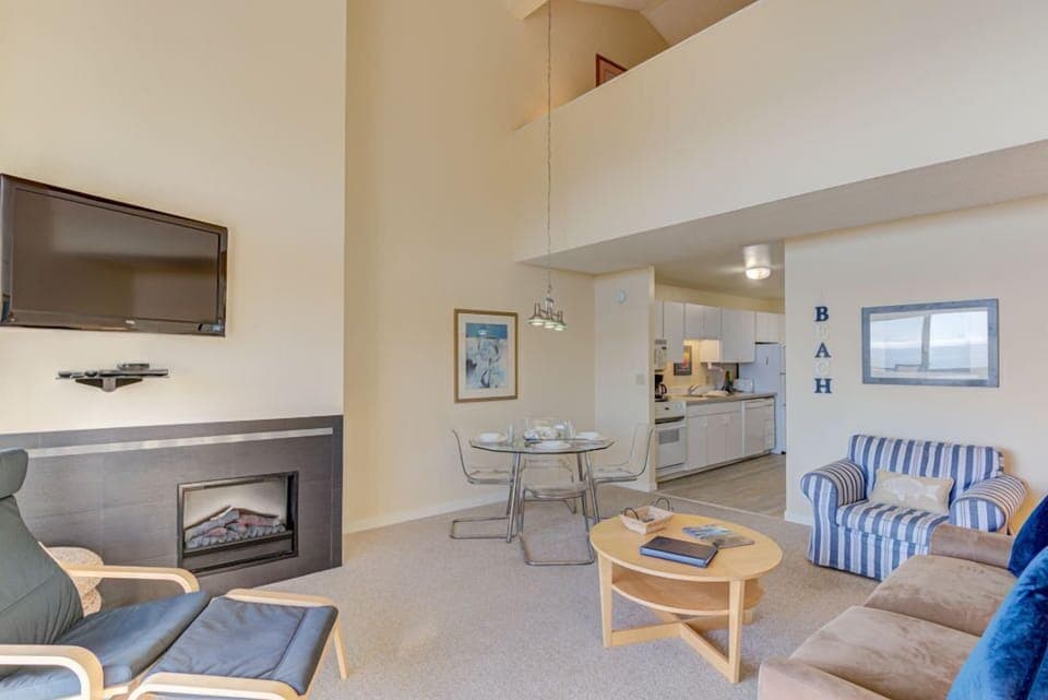 Elevate your experience in the airy living area, showcasing a flat-screen TV, a dining table, and an inviting ambiance with panoramic ocean views.