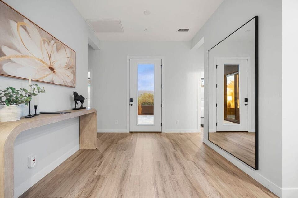 Modern front entry way with gorgeous decor and a large full sized mirror