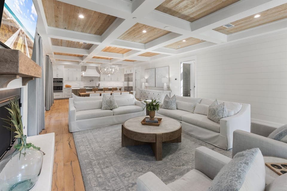Sink into plush seating beneath stunning coffered ceilings where natural light streams through, connecting your elegant living space to the gourmet kitchen.