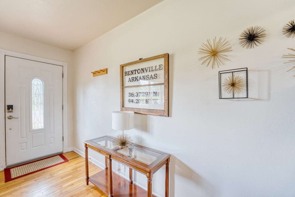 Step into elegance! This beautifully designed hallway in Bentonville, Arkansas features a stunning glass table and lamp that perfectly complement the space.