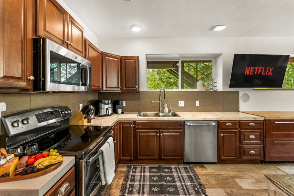 Secondary full sized kitchen on the terrace level with walkout to the lower terrace, a smart TV and dining table for 6