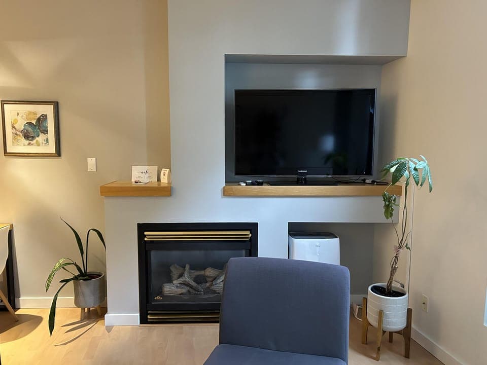 Relax in this bright, open-concept living space featuring floor-to-ceiling windows and a cozy gas fireplace for those cool West Coast evenings.