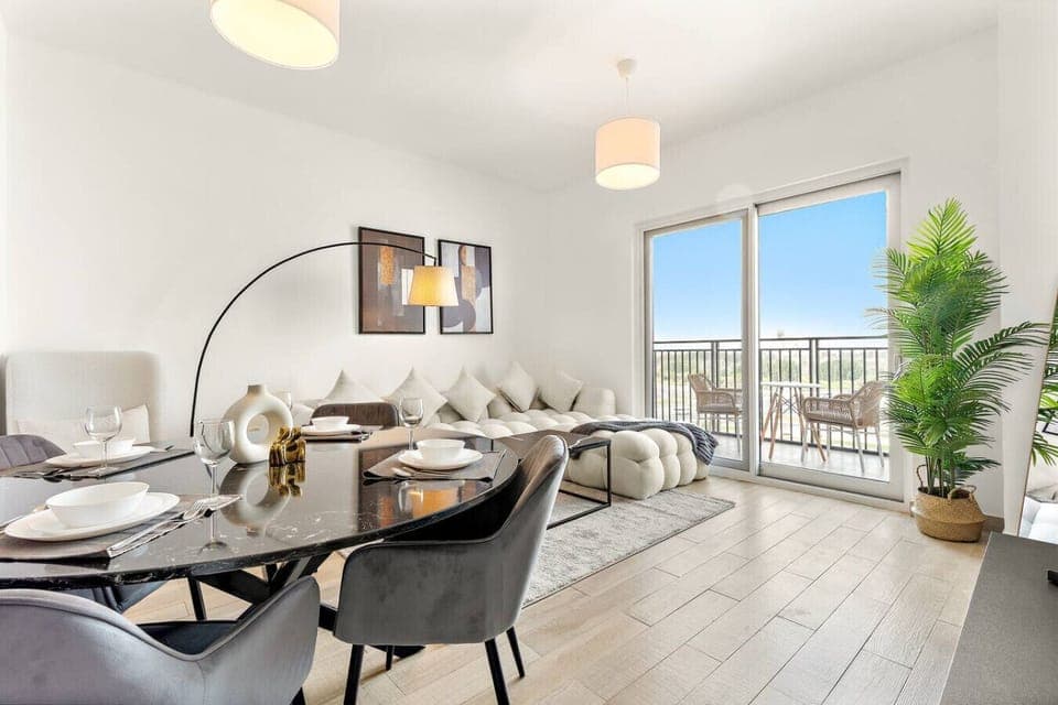 Bright lounge with plush sofa, balcony access, and stylish dining setup.