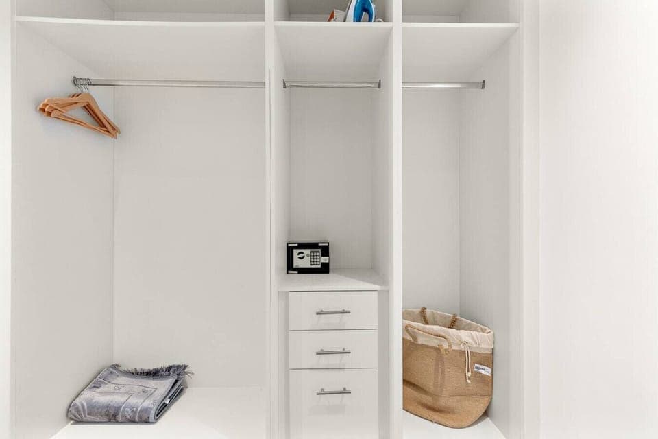 Ample built-in closet space with hanging rails and private safe.