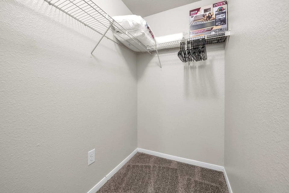 Bright closet area w/ upper shelving and room to keep items neatly tucked away.