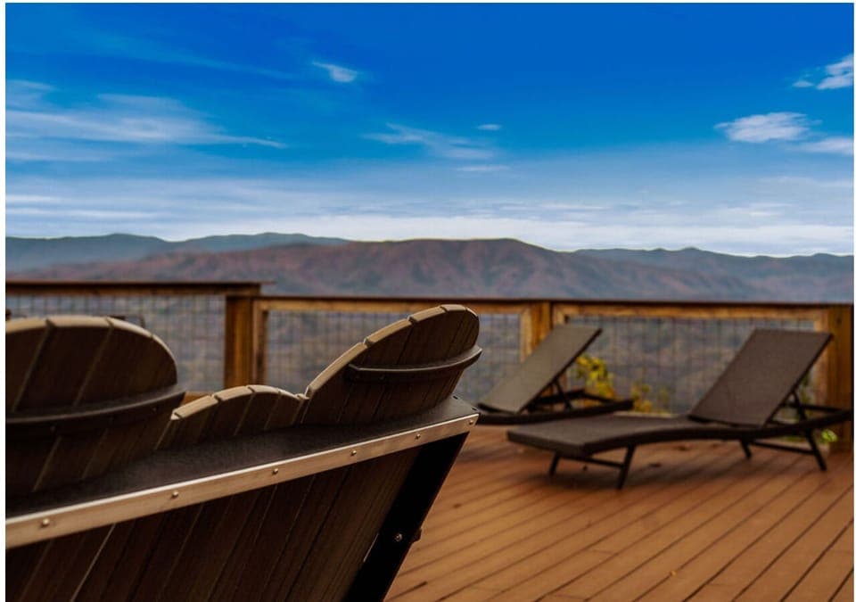 Deck seating area with comfortable chairs and mountain scenery