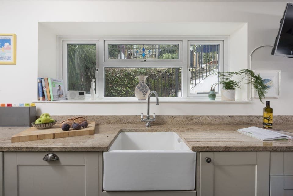 Kitchen area with garden view and sink - Trevethen Cottage