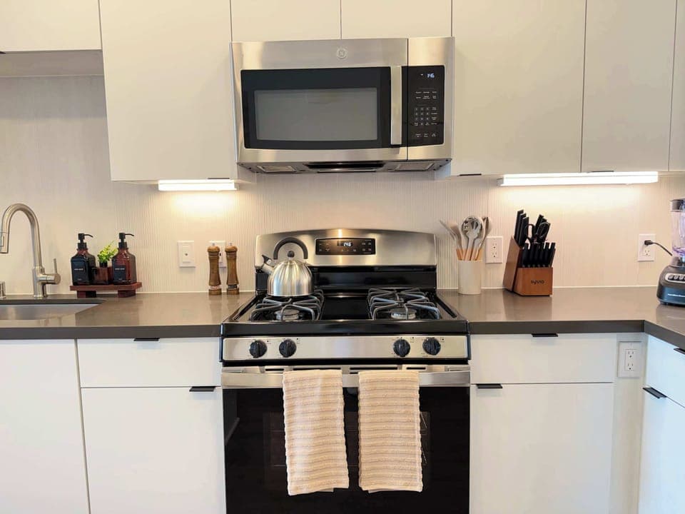 Experience extended comfort with a fully equipped kitchen featuring a coffee machine, stovetop, and microwave—everything you need for a seamless long-term stay.