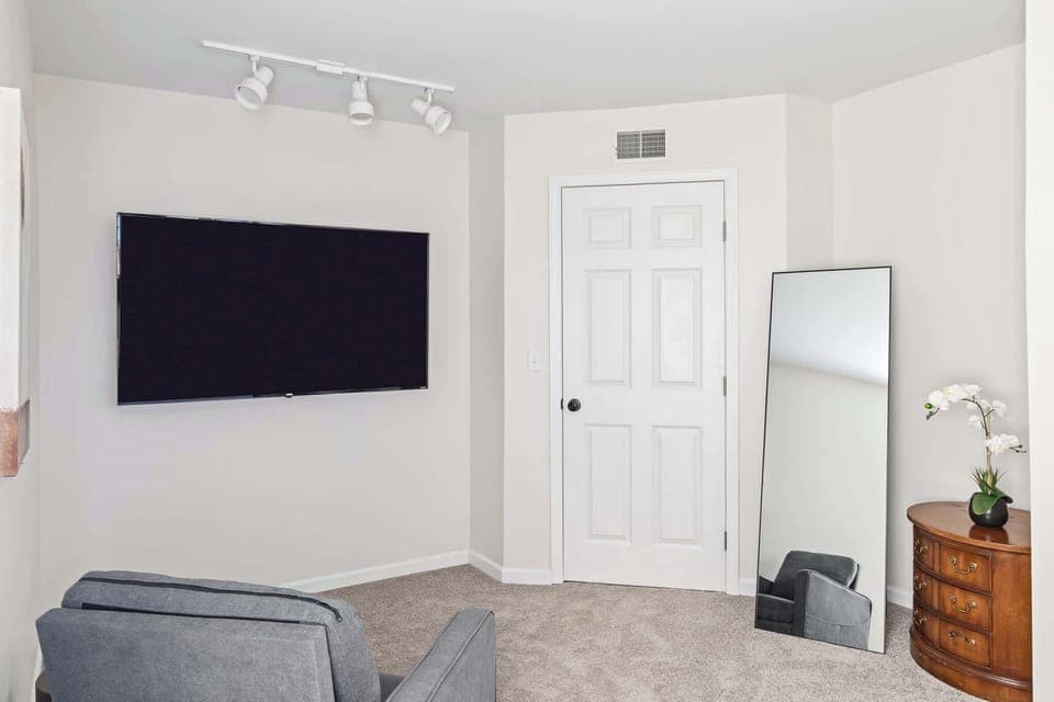 Comfortable bedroom w/ mounted TV & seating for relaxed evenings in.