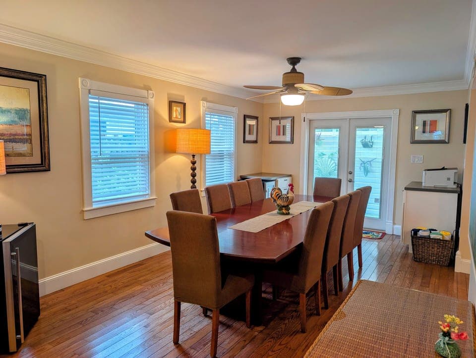 Bright dining room for 10 with hardwoods, fan, and patio access