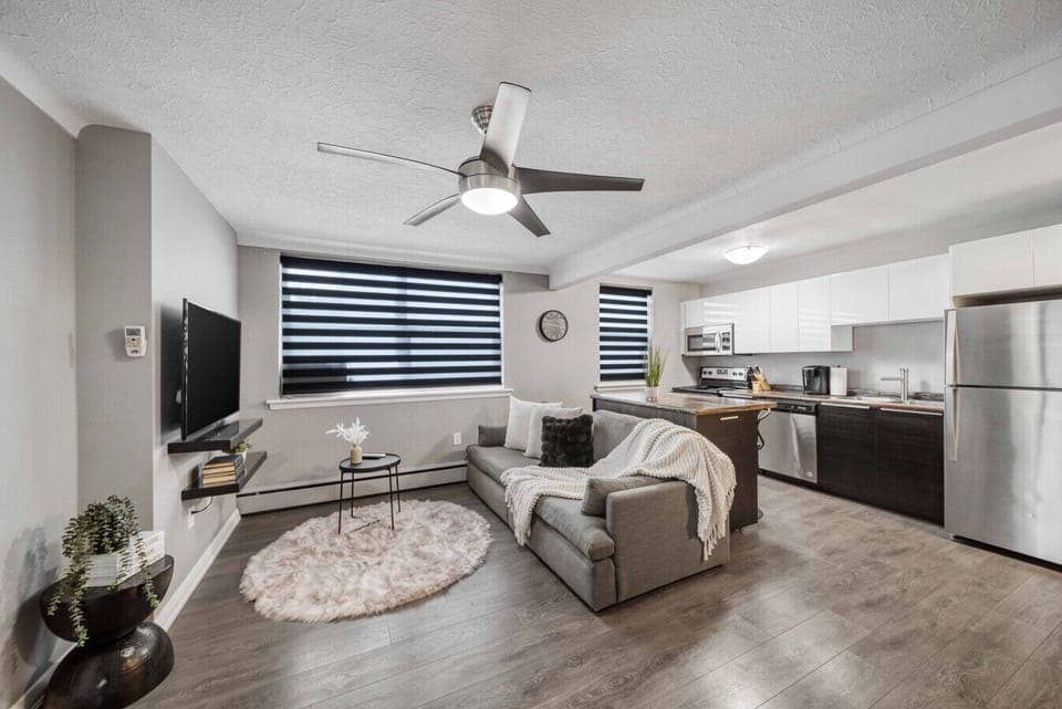 Experience modern comfort in our open-concept living & kitchen! Relax on the stylish sofa with a throw, enjoy entertainment on the TV, and cook in the fully equipped kitchen. Ceiling fan, chic blinds, and contemporary decor enhance your stay.
