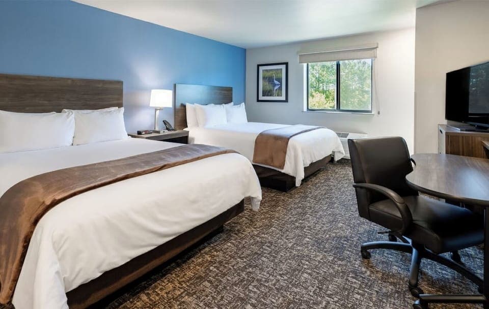 Unwind in a bright double-queen room with workspace comfort.