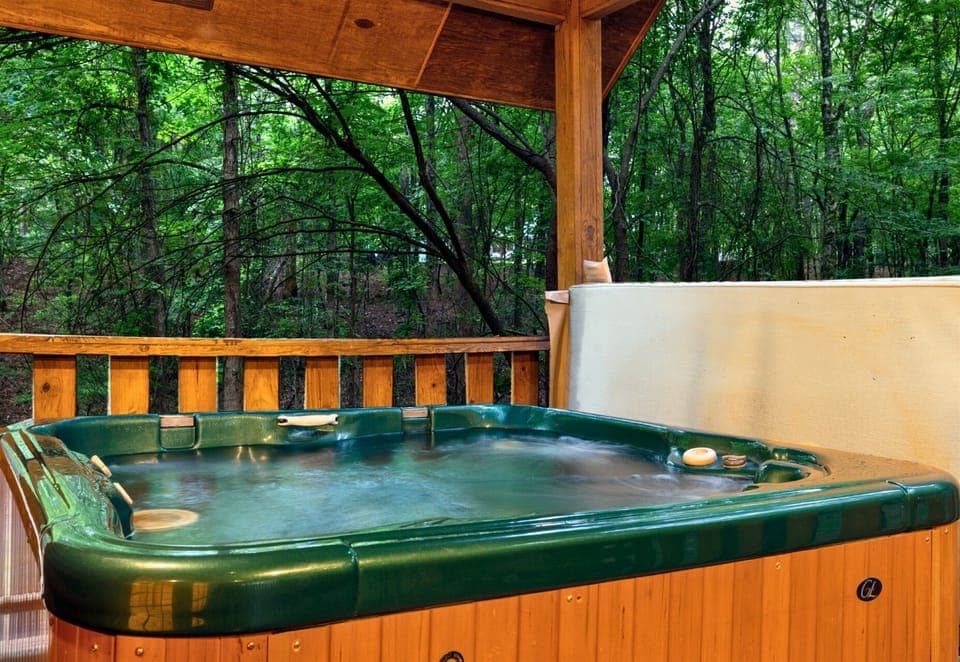 Soak in the private hot tub while surrounded by peaceful forest views.