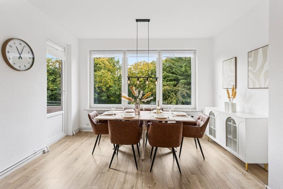 Ein großzügiger, lichtdurchfluteter Essbereich mit stilvoller Einrichtung und Ausblick ins Grüne bietet den perfekten Ort für gemeinsame Mahlzeiten.