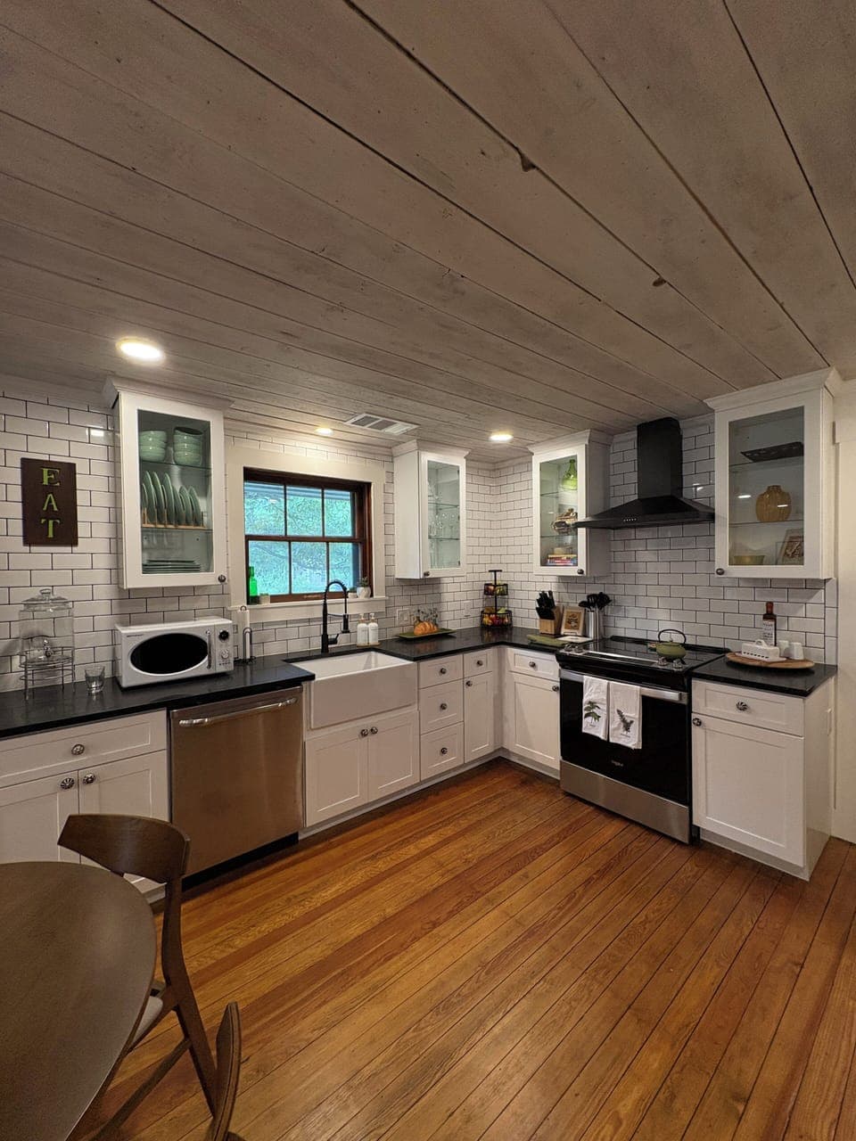 Kitchen features warm original hardwoods, window, and ceilings. All else is new!