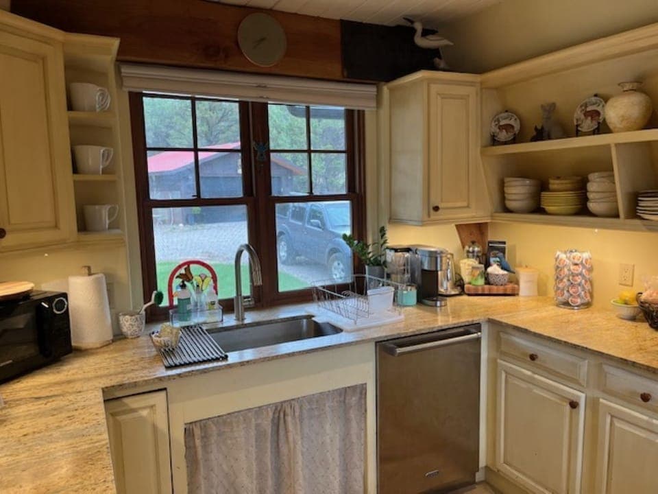 Charming kitchen with sink view to front entry to home