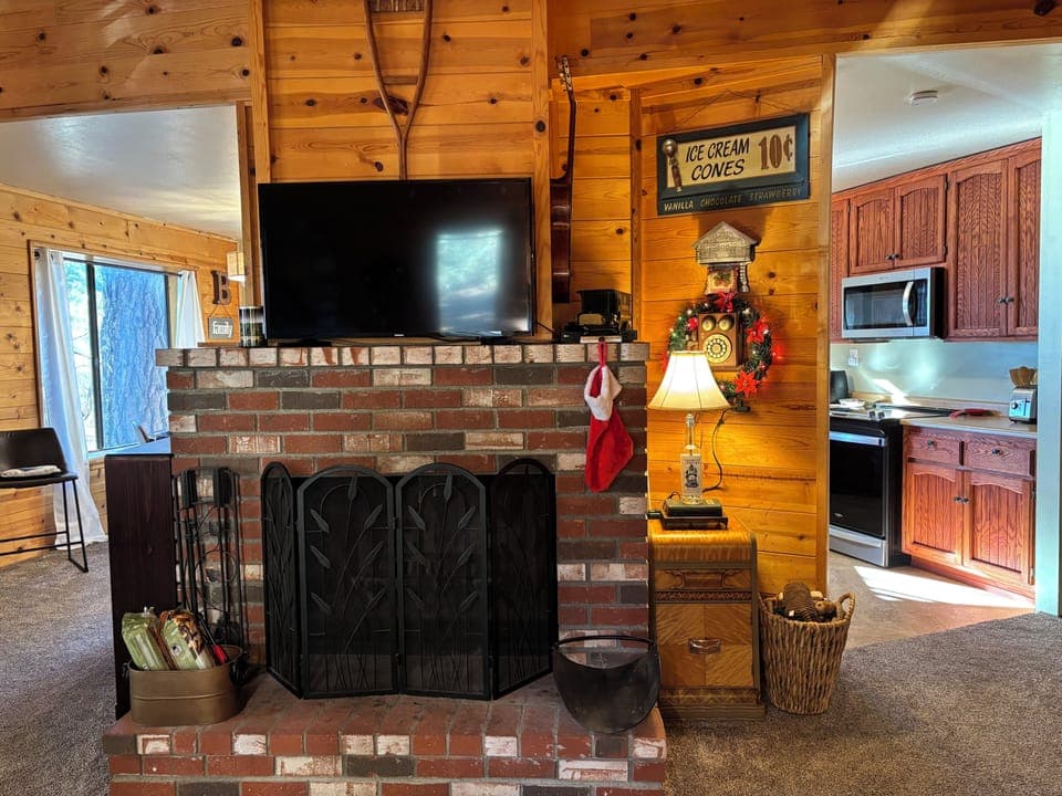 Living room with fireplace, smart TV, and open to kitchen and dining areas.