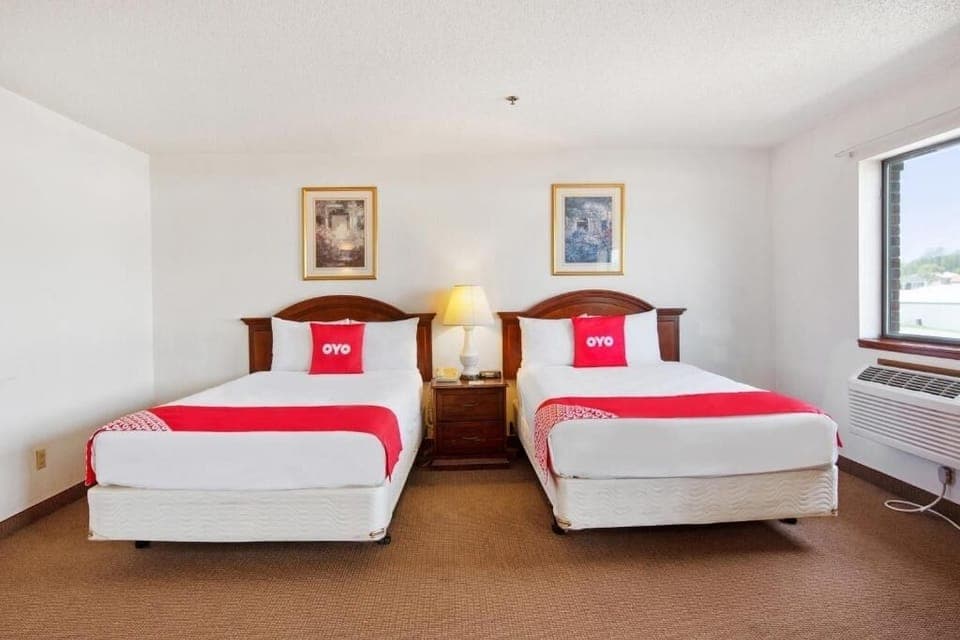 Unwind in bright double-queen comfort with cozy bedside lighting.