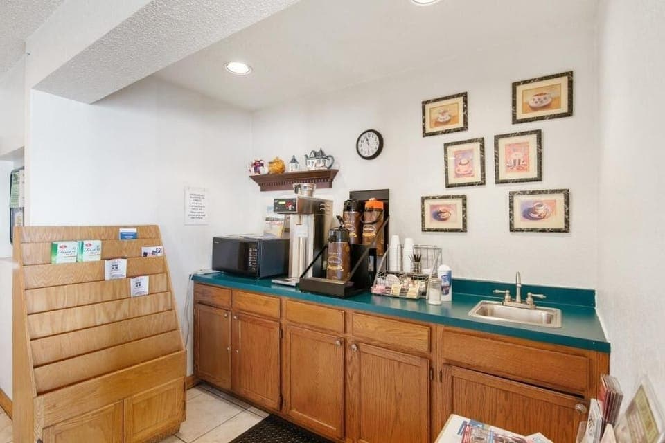 Lobby compact kitchen area with a coffee machine, microwave, and bulletin board.