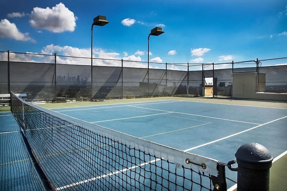 Play a rooftop match under blue skies and city breezes