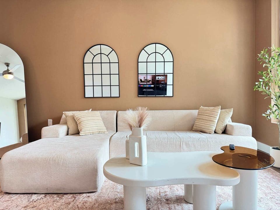 Spacious living room featuring a cozy L-shaped sofa, a full-size air mattress, and a 65" Smart TV with preloaded access to Netflix, Hulu, and Disney+, all set up for your enjoyment.