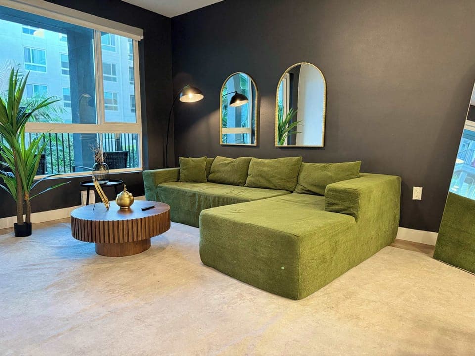 Spacious living room featuring a cozy L-shaped sofa, a full-size air mattress, and a 65" Smart TV with preloaded access to Netflix, Hulu, and Disney+, all set up for your enjoyment.