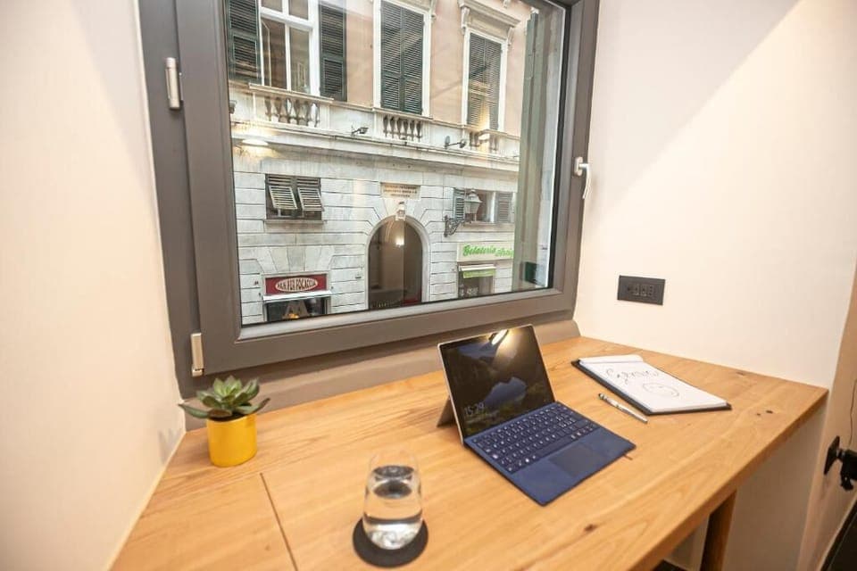 A dedicated workspace by a large window with stunning views of Via San Lorenzo, ideal for remote work or a relaxed session. Bathed in natural light, this calm corner offers comfort, inspiration and connectivity — perfect for business or leisure stays