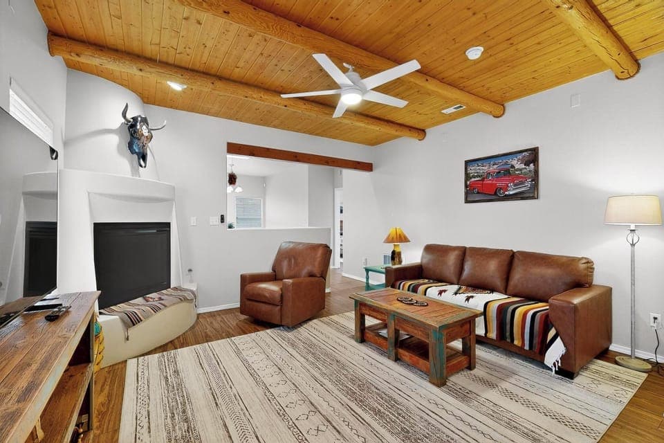 Relax in a cozy southwestern living room with rustic beams and a warm fireplace.