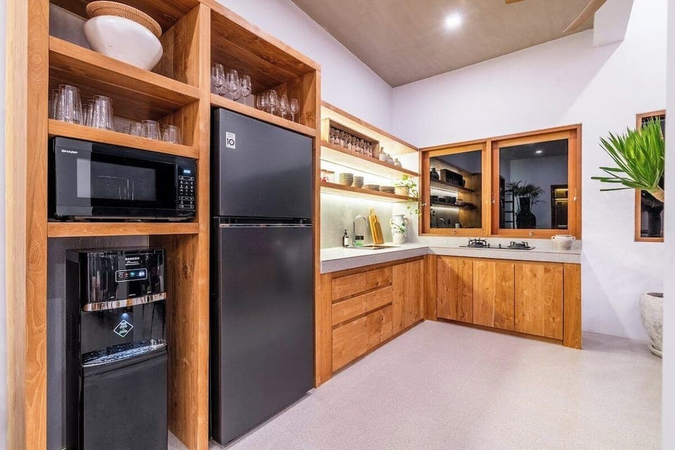 Kitchen with integrated appliances, ample storage, and a clean, airy feel. #Villa Samalas