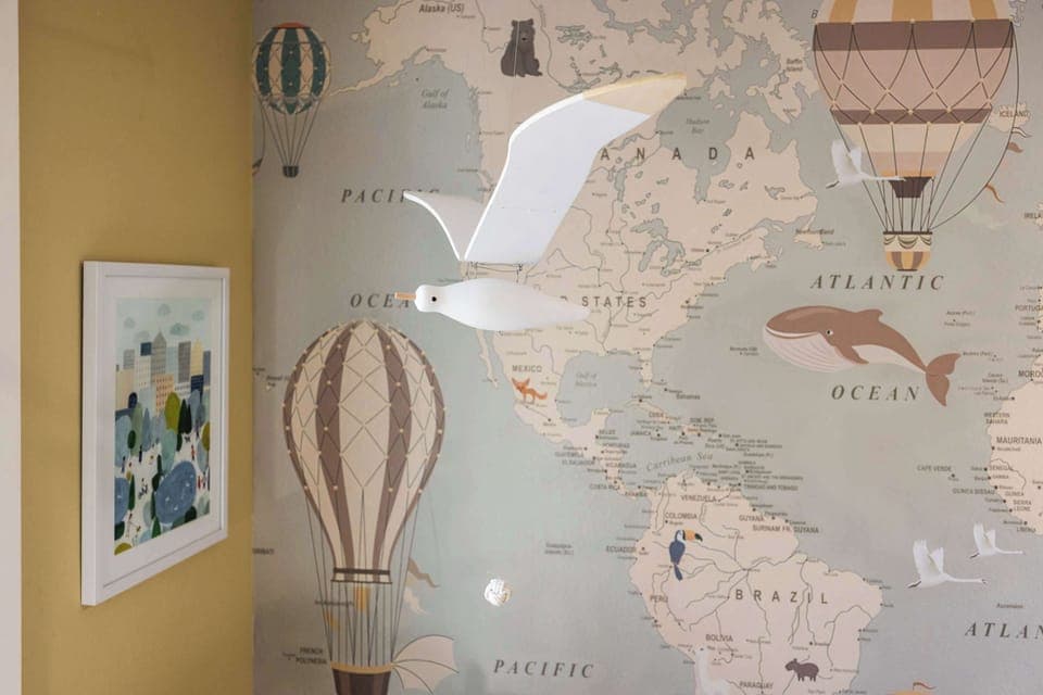 Whimsical seagull mobile adds charm to the travel-themed kids’ room.